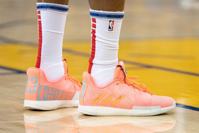 View of James Harden's coral adidas shoes.